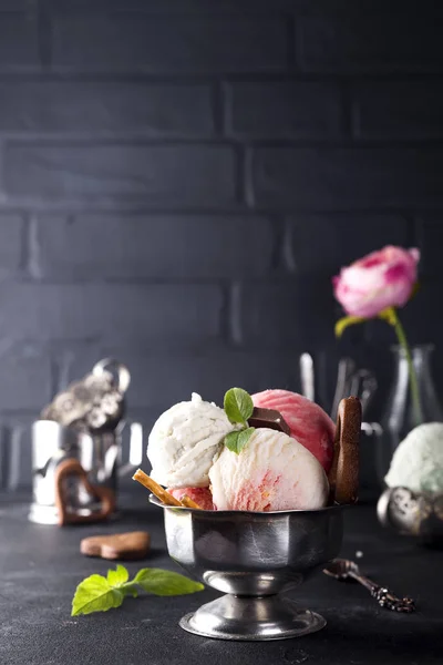 Vanille und rosa Eis in einer Schüssel mit gefrorenen Beeren und Waffelkegel — Stockfoto