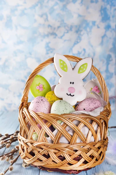 Пасхальное печенье, кролики и яйца в корзине на светло-голубом фоне — стоковое фото