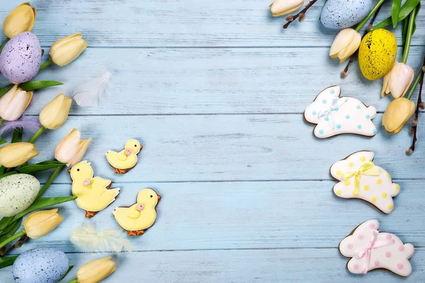 Marco de dulces para celebrar la Pascua. Pan de jengibre en forma de conejo de Pascua, pollo, huevos coloridos y tulipanes —  Fotos de Stock