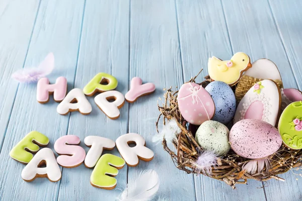 Carta colorida de galletas de huevo de Pascua Feliz Pascua en el nido sobre fondo de madera — Foto de Stock