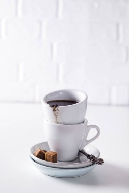 Beyaz bir arka plan üzerinde kahverengi şeker ile bir daire üzerinde siyah kahve