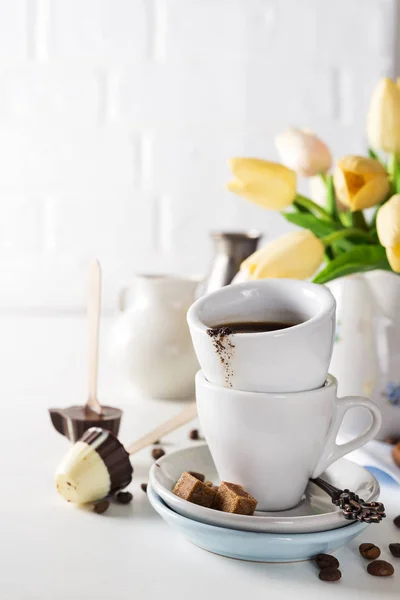 Kopje koffie met gele tulpen geïsoleerd op witte achtergrond. — Stockfoto