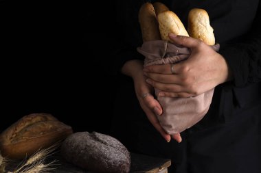 Rustik organik somun ekmek tutan eller - kırsal ekmek fırıncı kadın. Doğal ışık, karamsar natürmort.