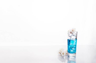 Mavi alkollü içki, üzerinde beyaz izole yakın çekim ile kokteyl cam kaynaklanıyordu. Örnek metin ile tasarım şablonu