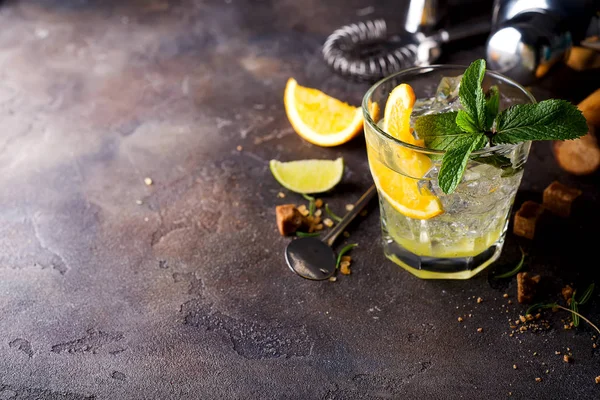 Oranje cocktail met ijs, blad van mint en oranje segment. — Stockfoto