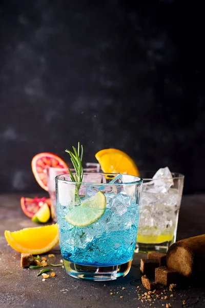 Coctel Blue Hawaiian Lagoon con ron malibú, curazao azul, vodka, tequila, zumo de naranja y menta sobre un fondo de hormigón oscuro — Foto de Stock
