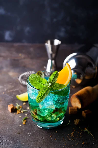 Alcoholic cocktail with sambuca, liqueur, orange juice, crushed ice and mint in dark stone background — Stock Photo, Image