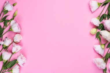 Merkezinde pembe Eustoma 'dan yapılmış boş bir boşluk olan çerçeve kompozisyonu düz yatıyordu. Pembe arka planda çiçek desenli köşeler.