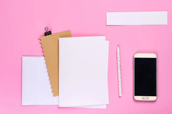 Mesa de trabalho com smartphone e notebook com espaço de cópia em fundo rosa, estilo mínimo flat lay — Fotografia de Stock