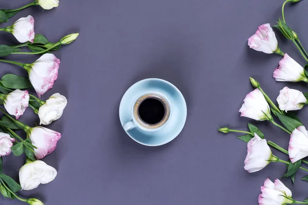 Xícara de café azul com buquê florescendo eustoma rosa em um fundo de papel preto com espaço de cópia, flat lay. Dia dos namorados, aniversário, mãe ou casamento cartão de saudação — Fotografia de Stock