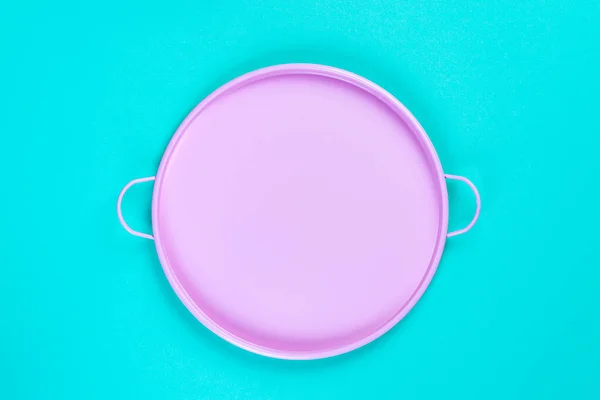 Bandeja de círculo de lata rosa sobre fondo de papel azul, vista superior con espacio de copia para su diseño, marco. Composición de naturaleza muerta . — Foto de Stock