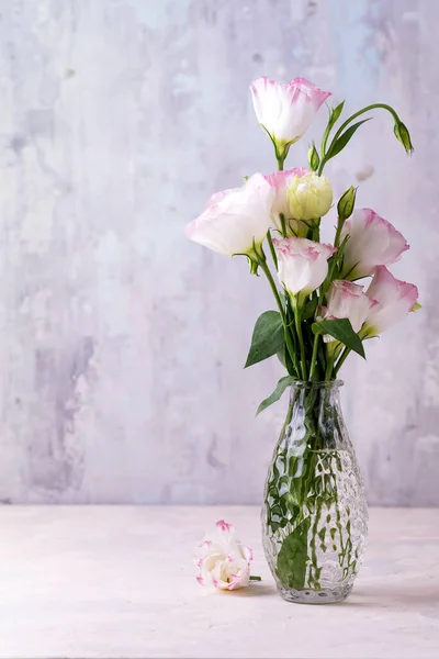 Eustoma fleurs dans un vase sur la table près du mur de pierre, espace pour le texte. Blank pour cartes postales — Photo