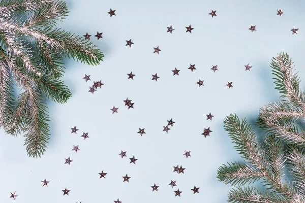 Moldura de composição de Natal feita de ramos de abeto com estrelas douradas no fundo azul. Natal, conceito de inverno. Flat lay, vista superior, espaço de cópia — Fotografia de Stock