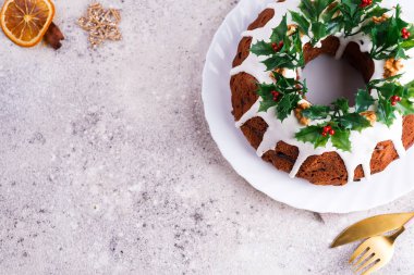 Noel 'de ev yapımı koyu çikolatalı kek, taşın üzerinde kutsal böğürtlen dallarıyla süslenmiş.