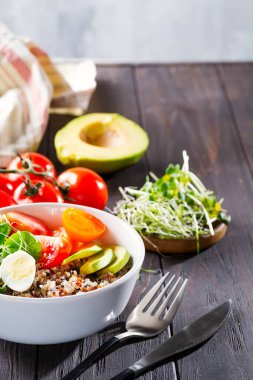 Kinoalı, yumurtalı, mikro yeşil sebzeli vejetaryen kahvaltısı, koyu ahşap bir masada naneli yeşil çay, düz uzanmış...