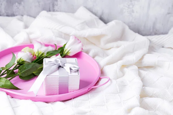 Confezione regalo e fiori pastello eustoma per San Valentino o Festa della Mamma su vassoio rosa sul letto. Stile flat lay . — Foto Stock