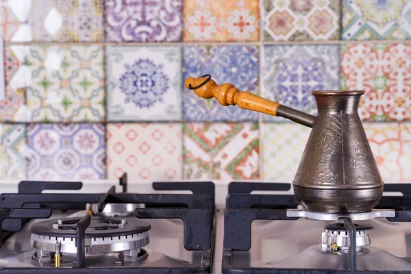 Μαγείρεμα καφέ σε ένα αέριο σόμπα. Παλιά τουρκική χάλκινο μπρίκι για τον καφέ ζυθοποιίας στο φούρνο στην κουζίνα. Πρωινό νωρίς. Τουρκική μέθοδος της ζυθοποιίας καφέ. — Φωτογραφία Αρχείου