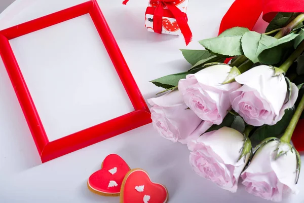 Domácí Valentines den srdce sušenky, růžové růže a červený rám na bílém stole, kopírovat prostor — Stock fotografie
