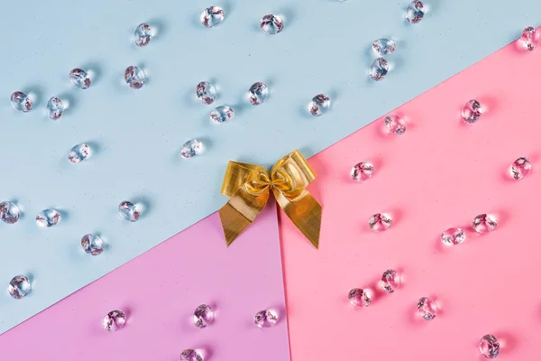 Golden ribbon ending with crystals in blue pink background, top view. — 스톡 사진