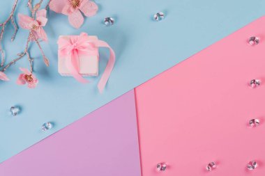 Pembe arka planda kristallerle sarılı küçük pembe kurdele. Tatil geçmişi. Minimum konsept. Düz yatıyordu. Üst görünüm.