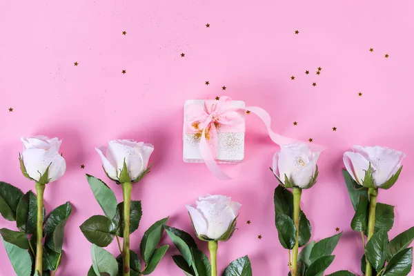 Pink rose and white gift box with pink ribbon on pink background — 스톡 사진