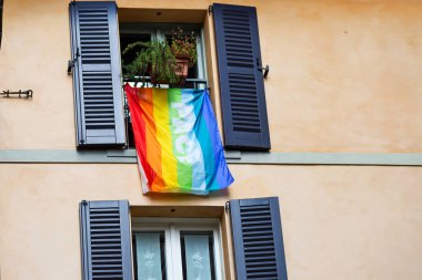lgbt renklerinin ve kelimenin bayrağı binanın ön cephesinde asılıdır, Bergamo