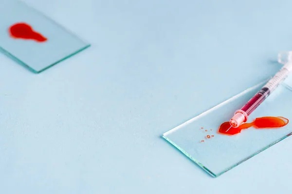 Tubos de ensayo con sangre en laboratorio sobre fondo azul — Foto de Stock