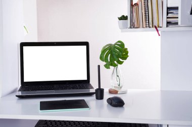Dizüstü bilgisayarı ve avuç içi yaprakları olan bir iş yeri. Evde ya da ofiste rahat çalışma masası