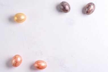 Güzel Paskalya gümüşü ve altın yumurtaları mermer arka planda