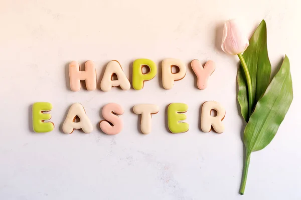 Feliz Pascua, Letras de galletas y tulipán rosa sobre fondo de mármol . — Foto de Stock