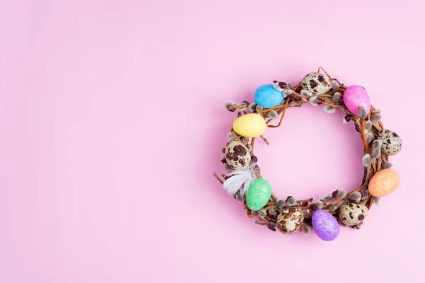 Corona de sauce de Pascua y coloridos huevos de Pascua sobre fondo rosa. Vista superior, espacio de copia —  Fotos de Stock
