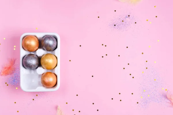 Bandeja de huevo de cerámica con huevos de Pascua pintados de oro y plata sobre fondo de estrellas rosadas, concepto de vacaciones —  Fotos de Stock