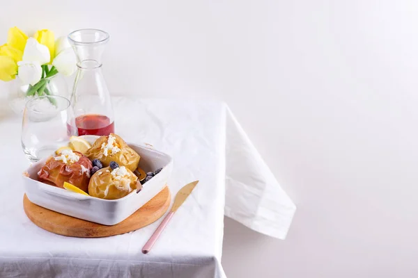 Bratäpfel mit Blaubeeren und Quark in Schüssel mit Besteck auf weißem Tisch — Stockfoto