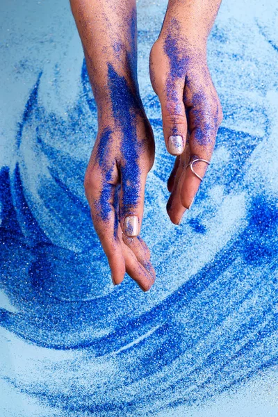 Abstract blue glitter sparkle background with woman hand. Beauty art concept — Stock Photo, Image