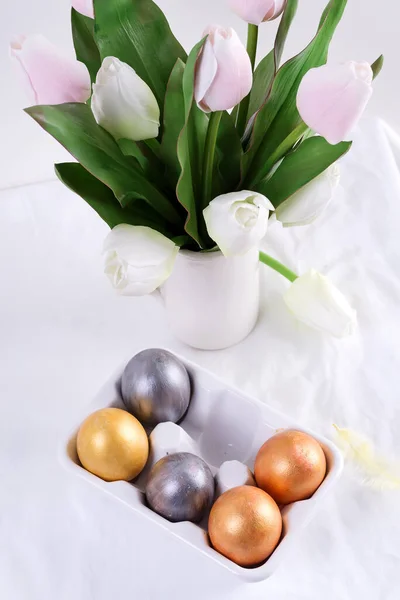 Greeting Easter card with handmade painted bright eggs and bouquet of fresh tulips flowers on a light textile background. — 图库照片