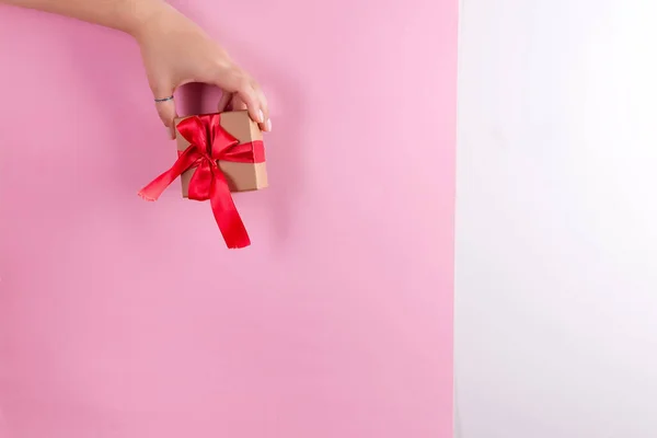 Вітальна Листівка Жіночої Руки Тримає Подарункову Коробку Червоною Стрічкою Фоні — стокове фото