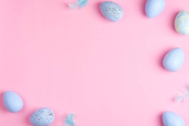 Tebrik köşesi çerçevesi boyalı pastel mavi renkli yumurtalar ve açık pembe arka planda açık renkli kuş tüyleri, kopyalama alanı. Mutlu Paskalyalar.