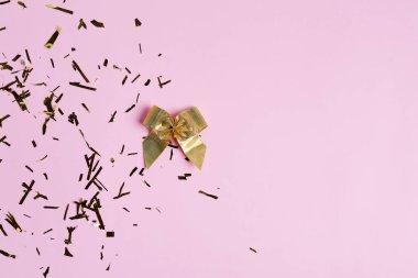 Altın yay ve karnaval arasındaki karşılama köşesi pembe arka planda parlak bir konfeti.