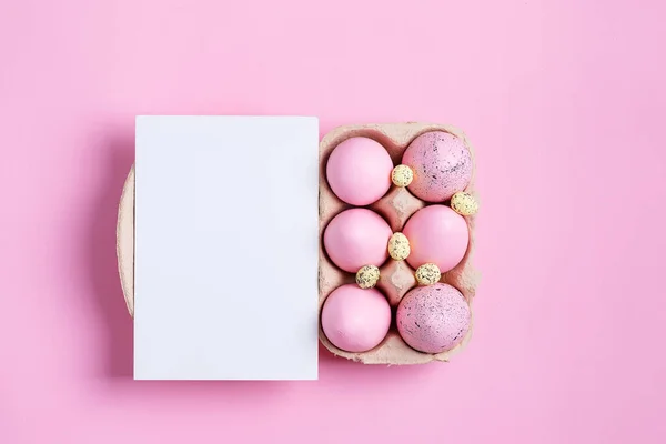 Recipiente de papel de artesanato rosa pintado ovos de Páscoa e folha de cartão de papel em um fundo da mesma cor . — Fotografia de Stock