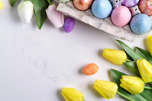 Huevos de Pascua en caja con tulipanes amarillos sobre fondo de mármol de piedra. Fondo de Pascua o concepto de Pascua . —  Fotos de Stock