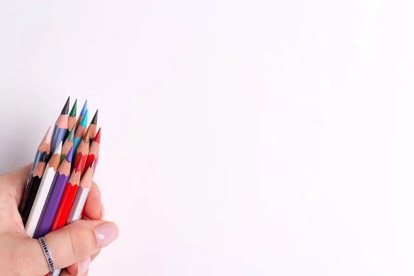 Ζωγραφική γωνία πλαίσιο με το χέρι των γυναικών κρατά δέσμη πολύχρωμα μολύβια για τη δημιουργικότητα τέχνη σε λευκό φόντο. — Φωτογραφία Αρχείου