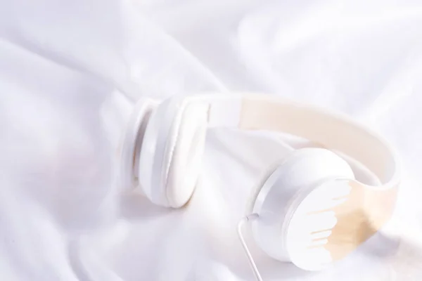 White headphones for music on a white bed — Stock Photo, Image