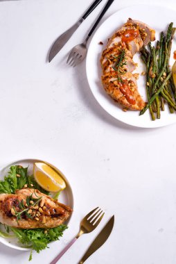 Izgara tavuk göğsü ızgara kuşkonmaz ve arka planda limon dilimi. Paleo diyeti.