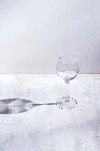 Вино стекло с солнцем жесткий свет тень отражение на каменном фоне — стоковое фото