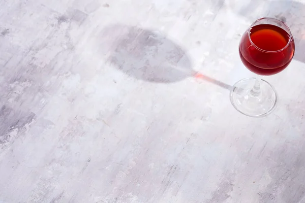 Vino tinto en una copa de vino con sombras aisladas sobre fondo de piedra —  Fotos de Stock