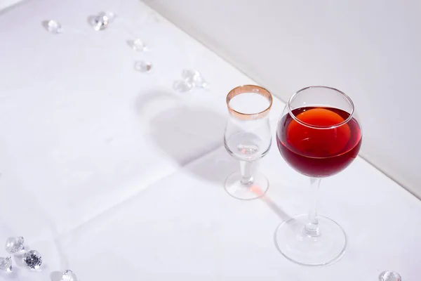 Червоне вино в келиху з тінями ізольоване на білому текстильному фоні — стокове фото