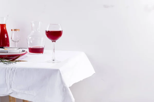Червоне вино в келиху, декантер і обстановка столу з тінями ізольовані на білому текстильному фоні — стокове фото