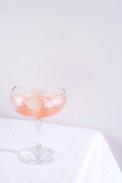 Cóctel rosa con hielo sobre un mantel blanco sobre la mesa —  Fotos de Stock