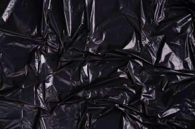 Buruşmuş siyah plastik polietilen paketinin yaratıcı arkaplanı