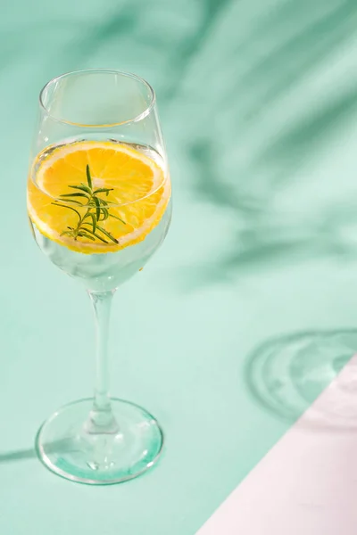 Summer homemade cold cocktail in a glass with lemon slice on a duotone background with leaf shadows. — Stock Photo, Image